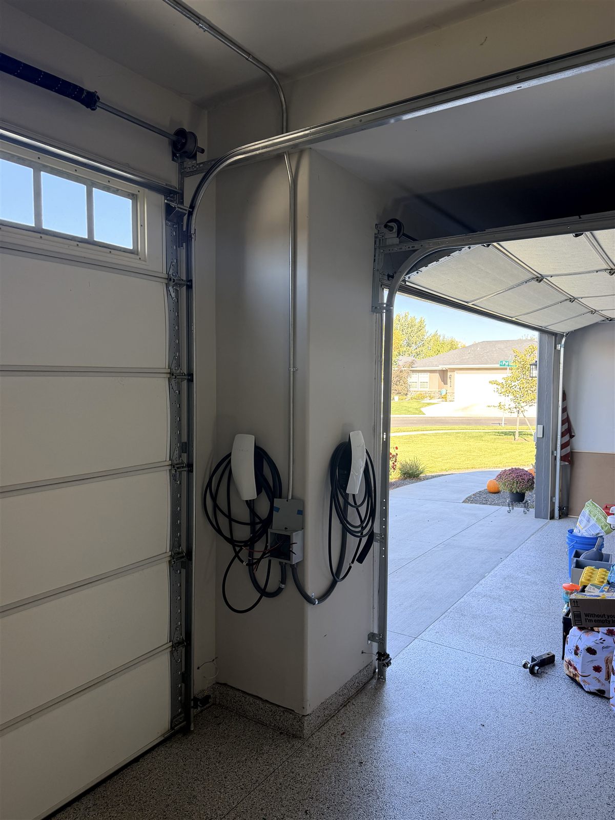 Two wall-mounted EV chargers installed in a residential garage by Walker Electric